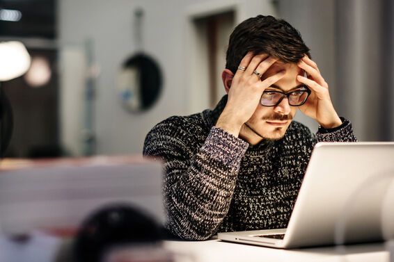 Young businessman holding his head and thinking deeply