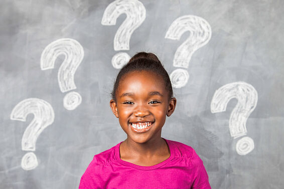 Question marks on blackboard with kid